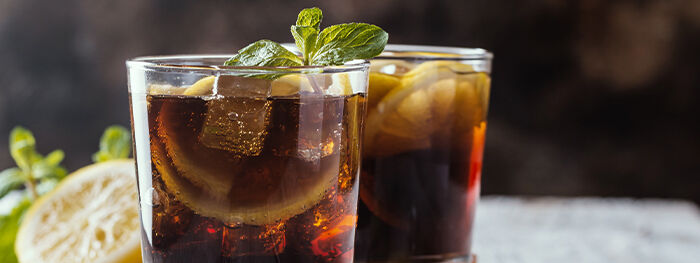 Rum-Cocktail mit Eiswürfeln, Zitronen und Minze, Cuba Libre Rum-Cocktail mit Eiswürfeln, Zitronen und Minze, Cuba Libre