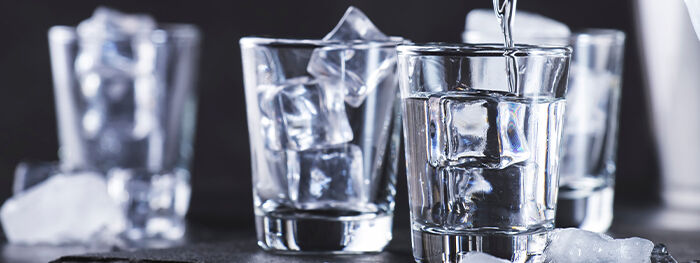 Vodka mit Eiswürfeln in Schnapsgäsern Vodka mit Eiswürfeln in Schnapsgäsern