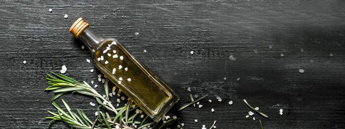 Mood Flasche mit Olivenöl liegt auf Holzplatte Mood Flasche mit Olivenöl liegt auf Holzplatte