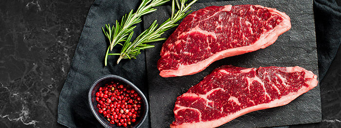 Zwei Stücke Fleisch auf Schieferplatte Zwei Stücke Fleisch auf Schieferplatte