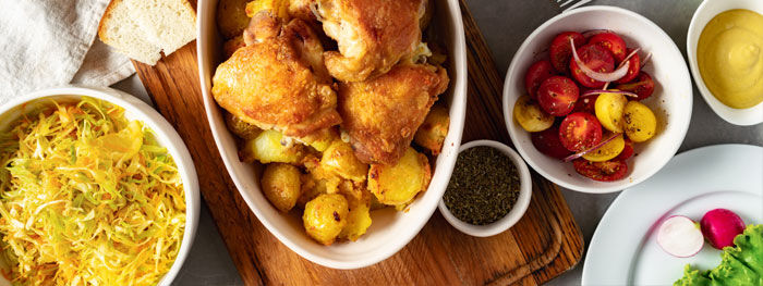 Gebackene Hünchenfiletstücke mit Kartoffeln, Kraut- und Tomatensalat